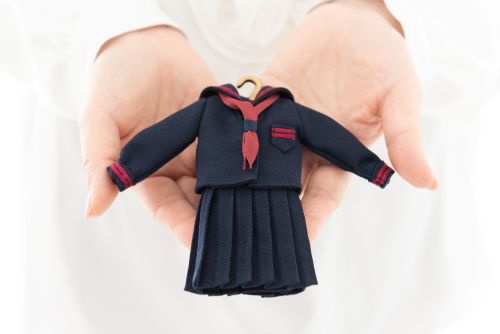 ミニチュア制服を持つ手